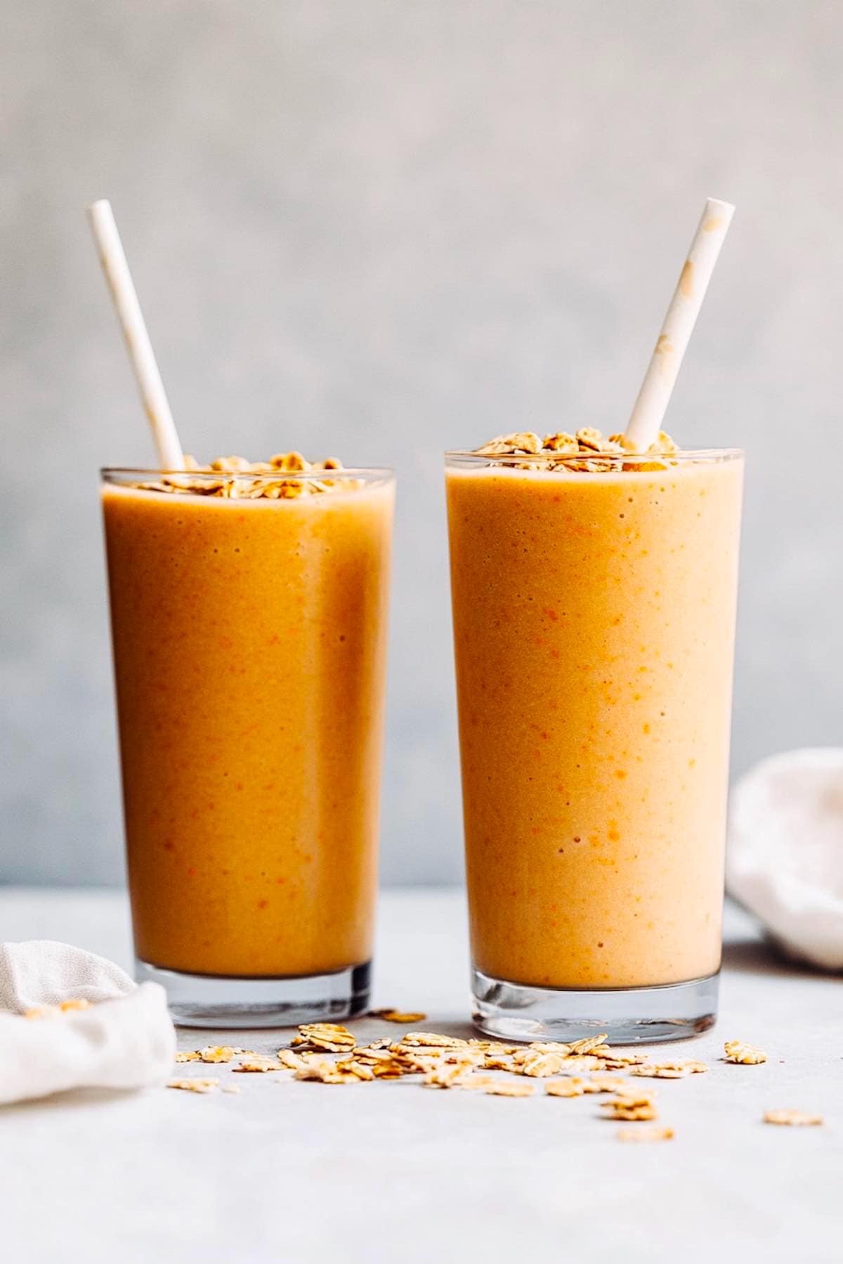 two carrot smoothies in glasses.