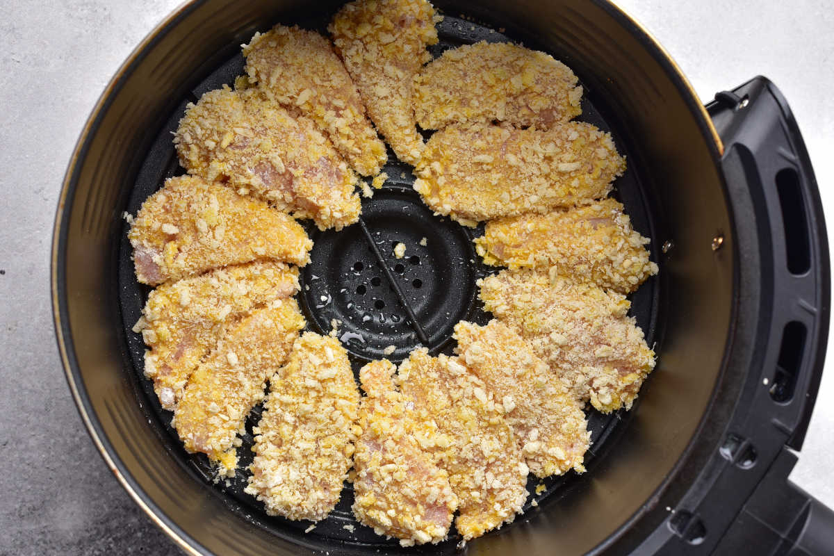 raw chicken nuggets in the air fryer basket.