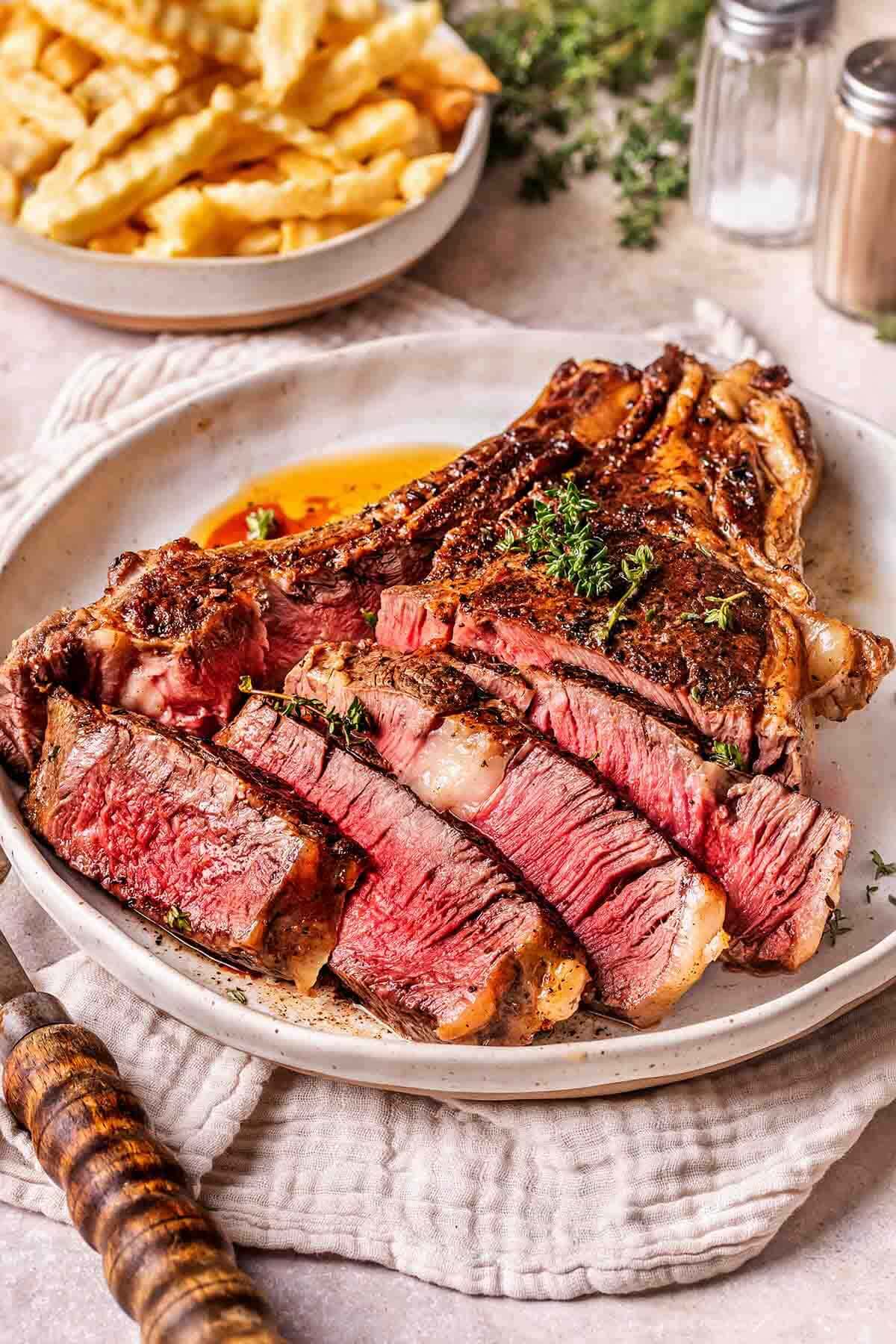 sliced cowboy steak on a plate.