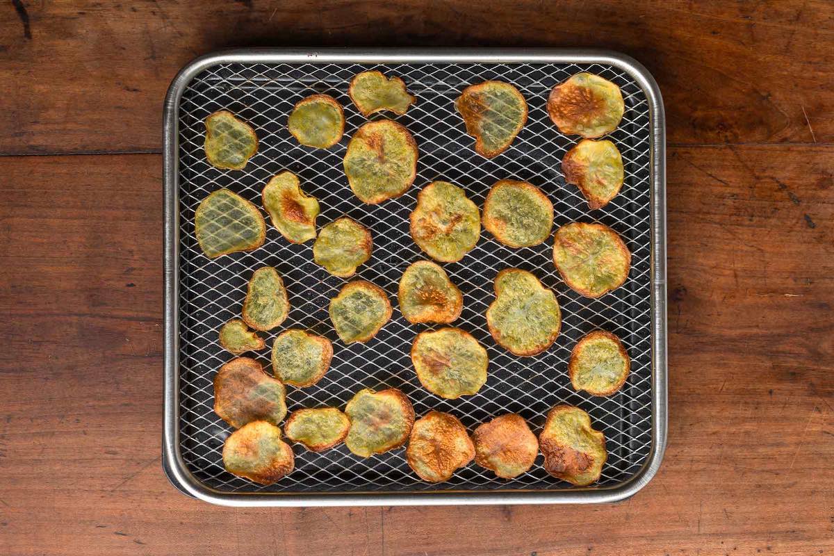 cooked potato chips on air fryer basket.