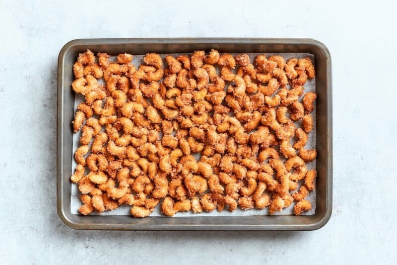 coated cashews on a baking sheet.