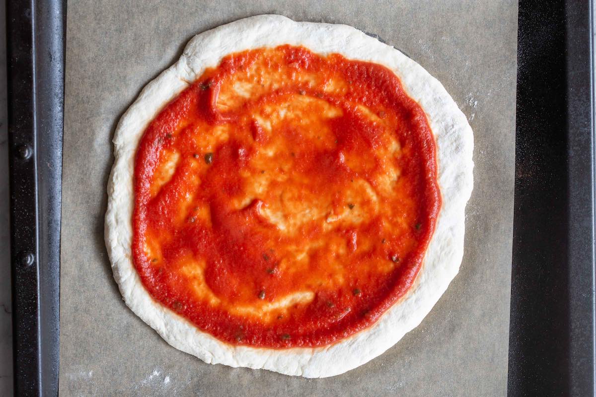 pizza dough with sauce.