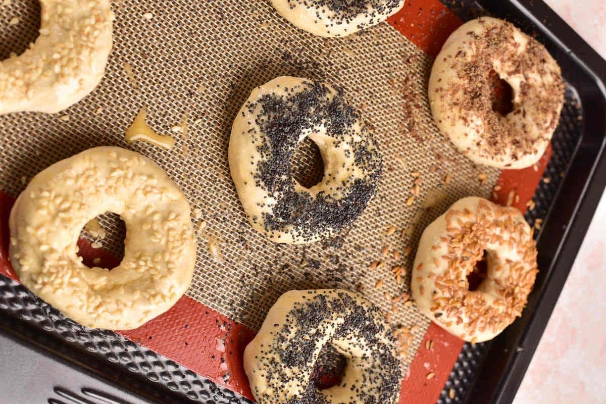 pre-baked protein bagels on a baking sheet.