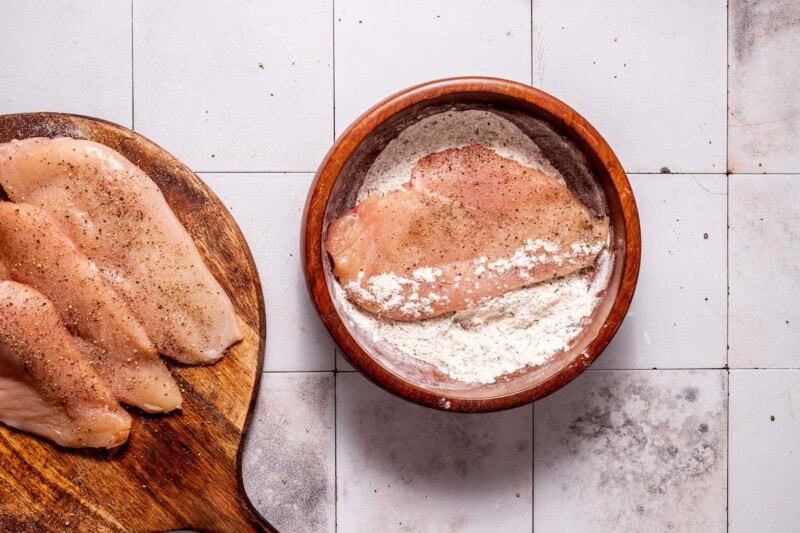 seasoned chicken breast fillets in flour.