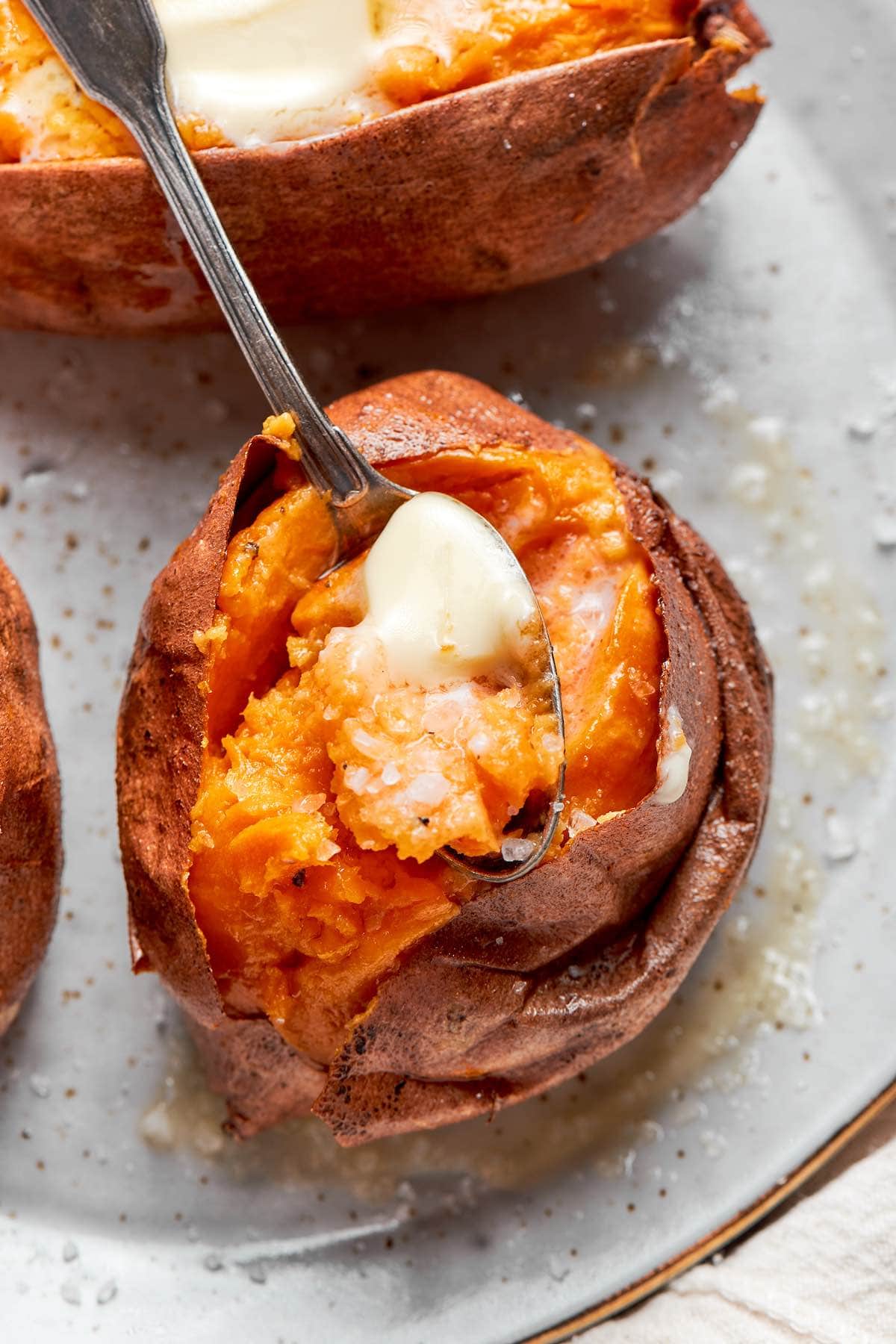 split microwave sweet potato with butter on top.