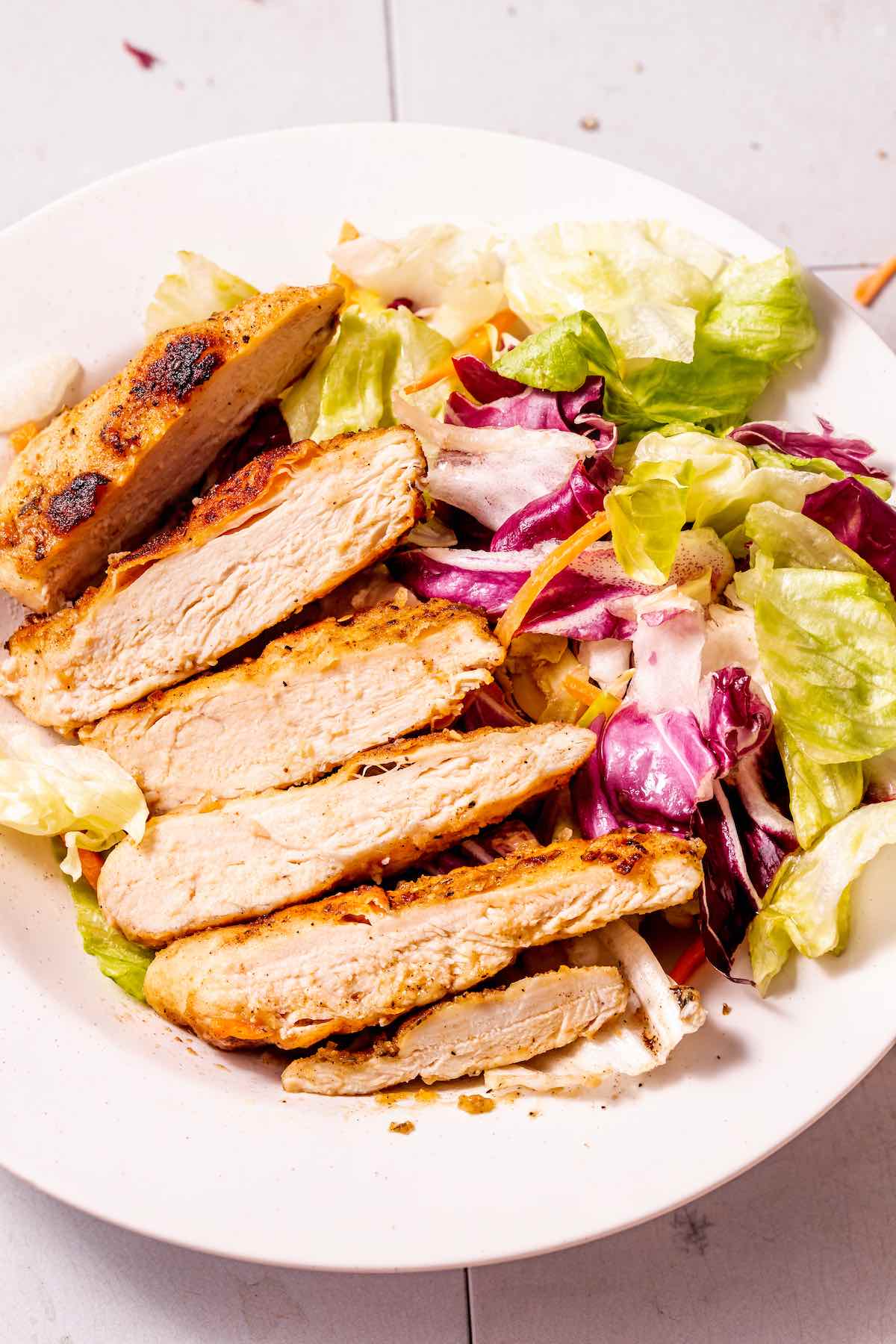 pan fried chicken breast with salad.