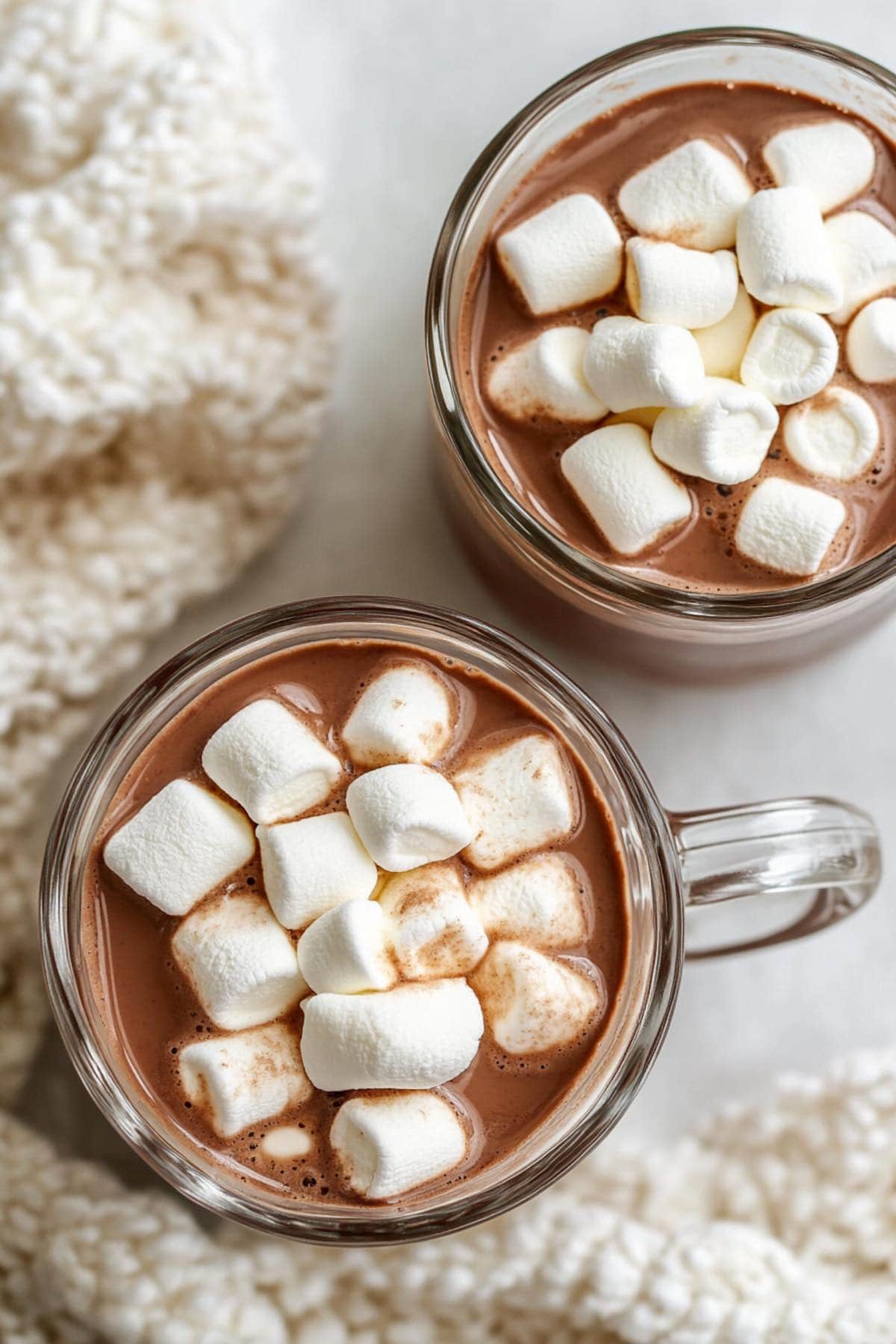 two mugs of protein hot chocolate with marshmallows on top.