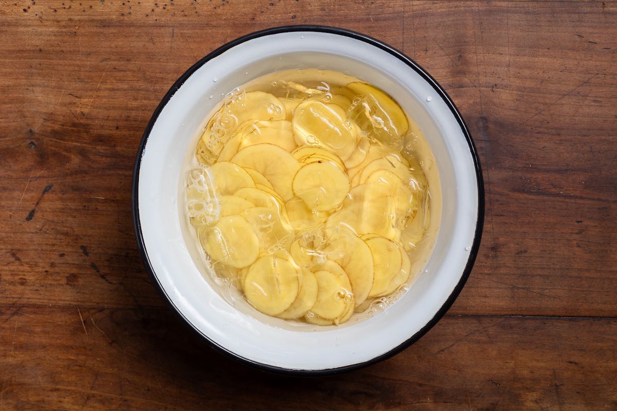 potato slices in bowl with water.