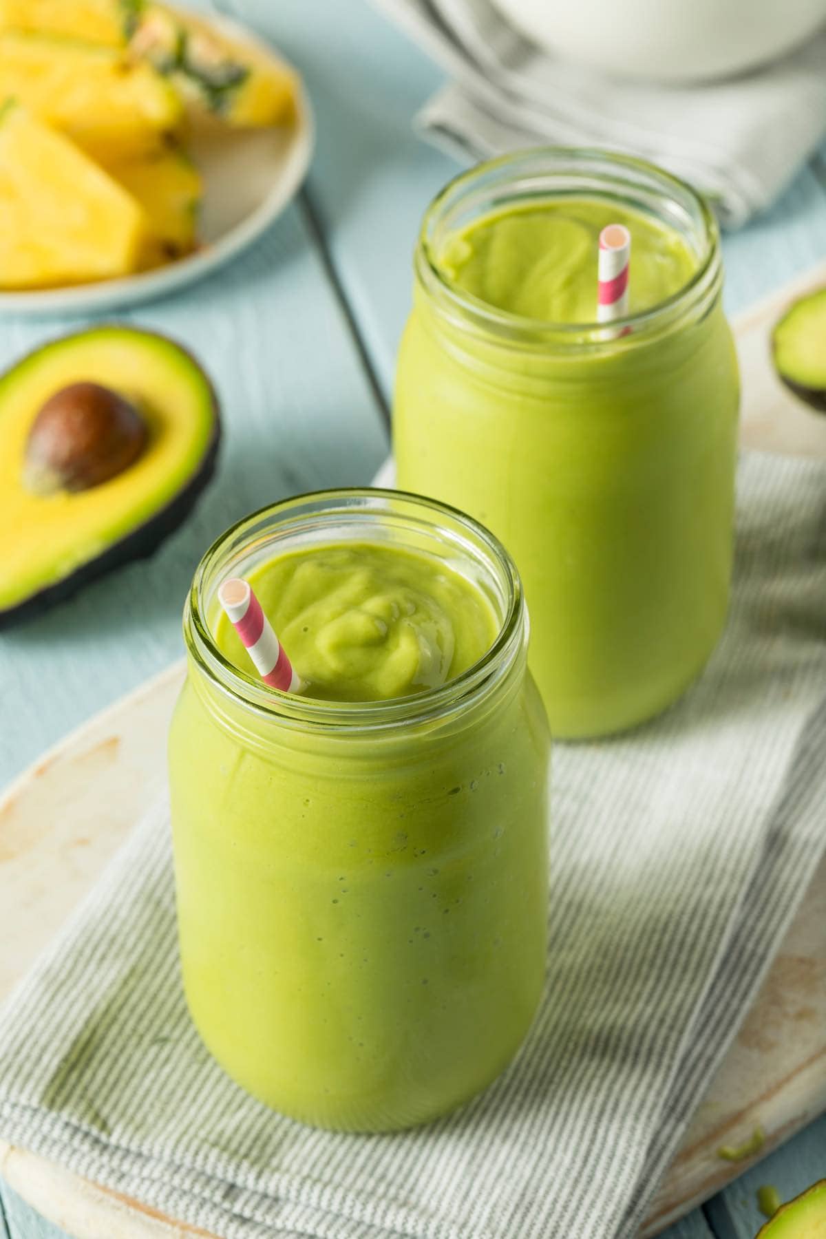 two avocado smoothies in glasses.