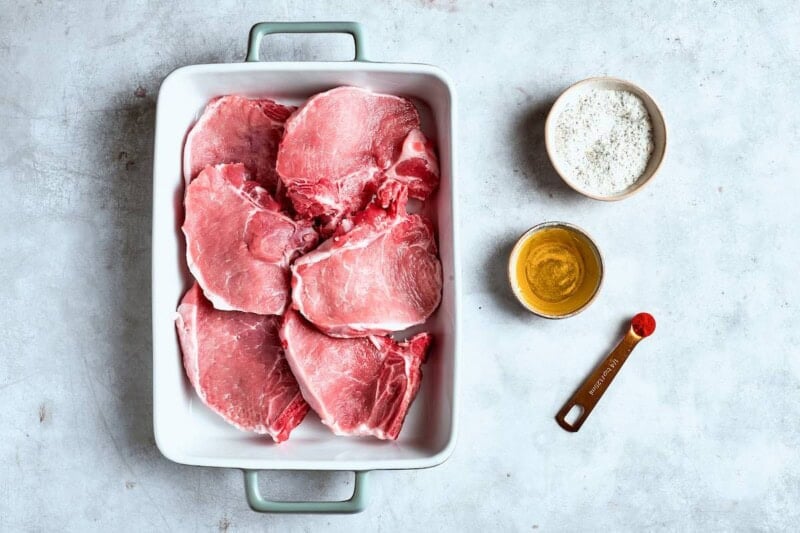 Raw pork chops dried and in a baking dish.