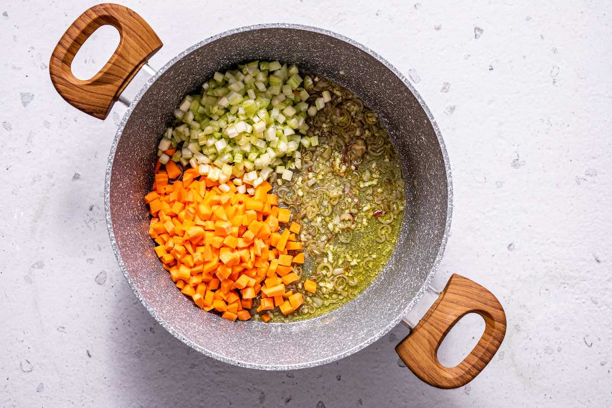 vegetables, garlic, and onion sauteing in a pot.