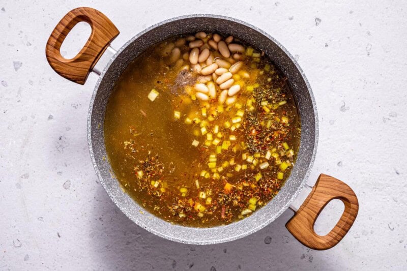 ingredients in the soup pot with broth poured on top.