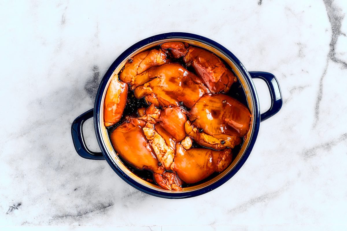 chicken marinating in a pot.