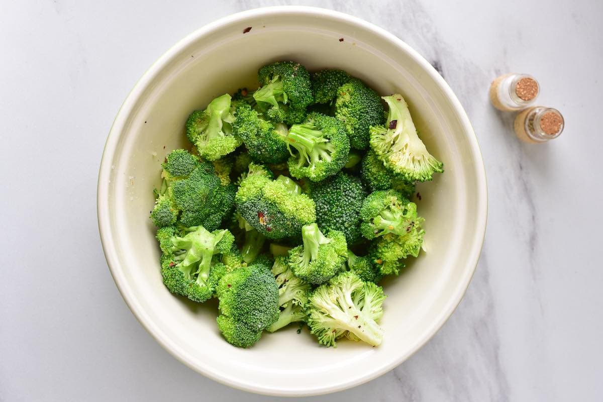 seasoned raw broccoli florets in a bowl.