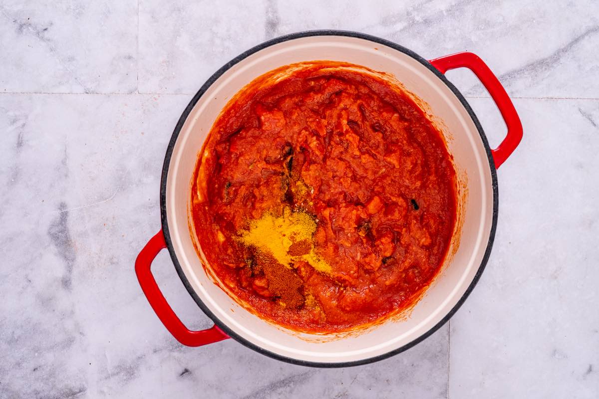 tomatoes with spices simmering in a pot.