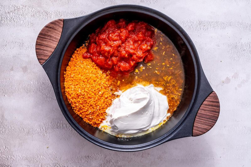 coconut cream, red lentils, tomato puree, and broth in a pot.