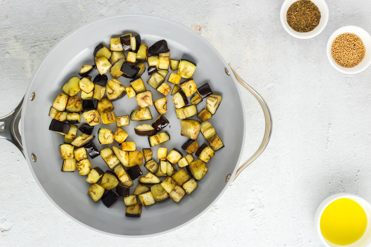 chopped eggplant sauteeing in a skillet.