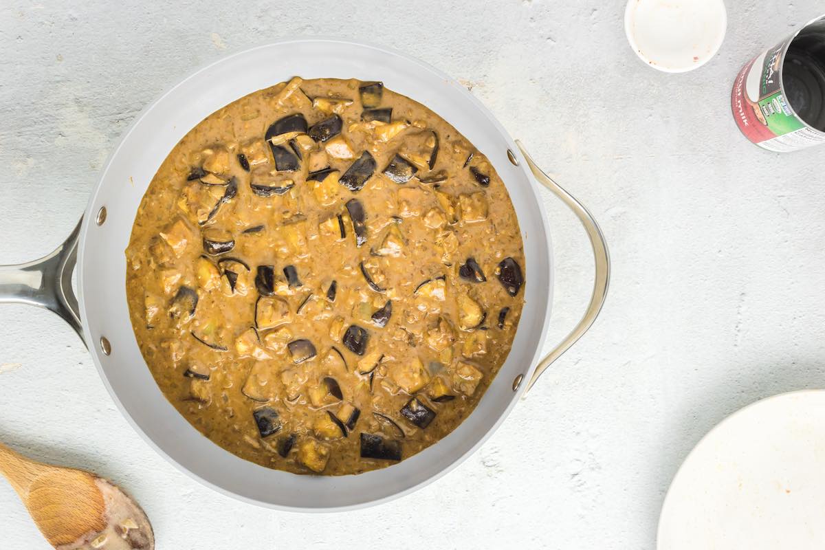 curry mixture with eggplant simmering in a skillet.