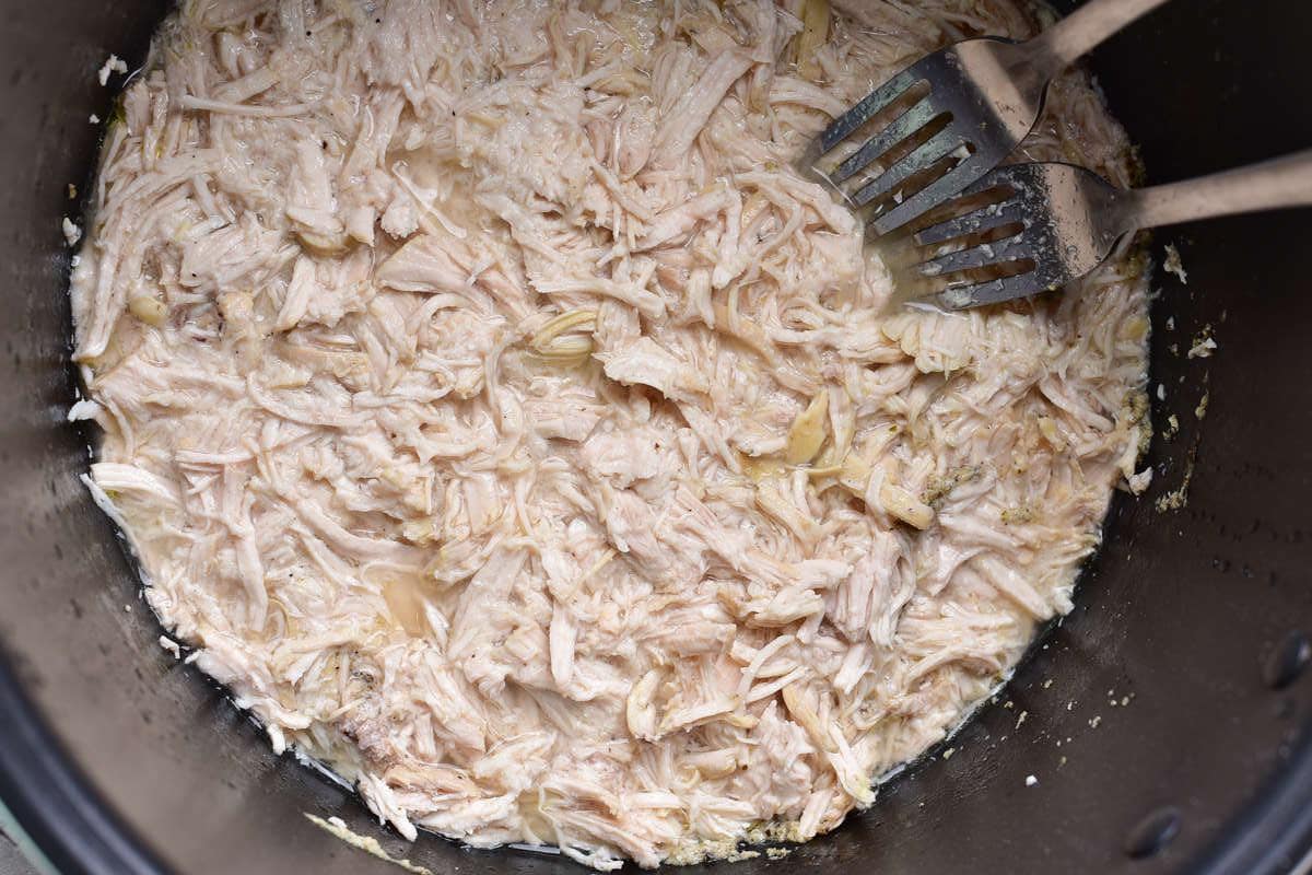 shredding chicken with two forks.