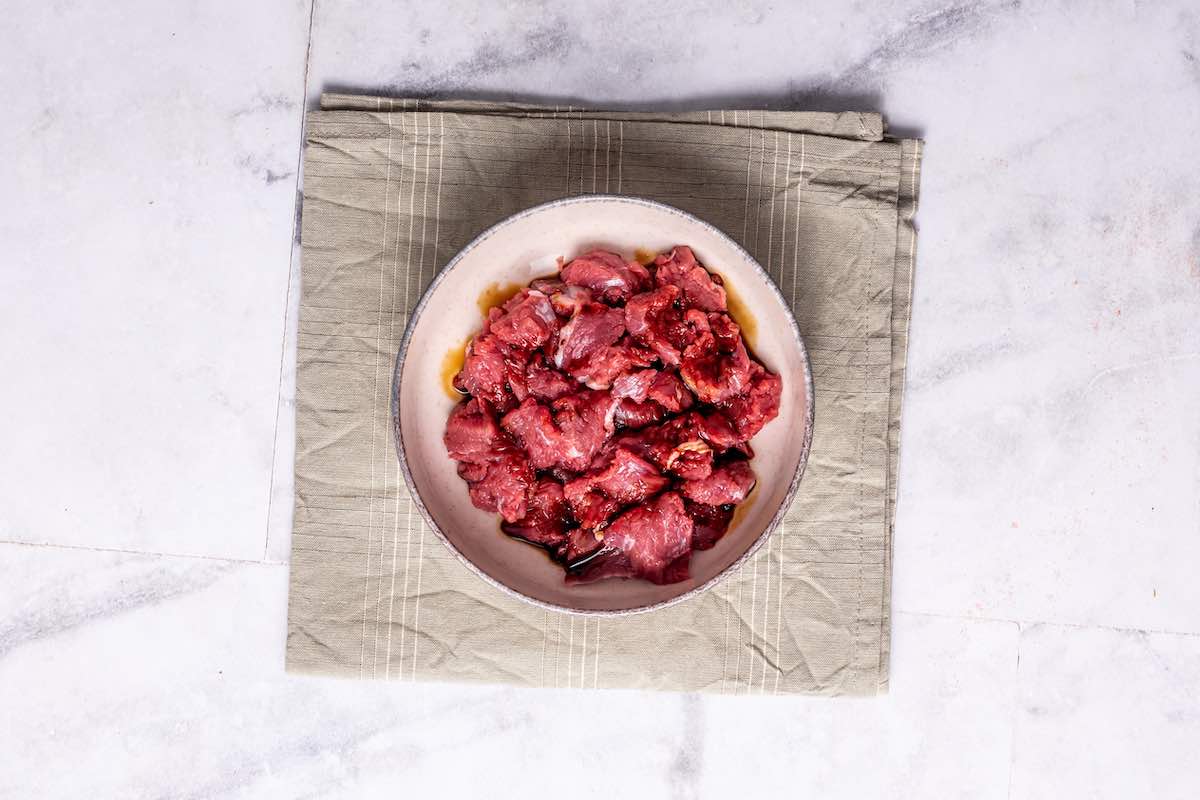 steak marinating in a bowl.