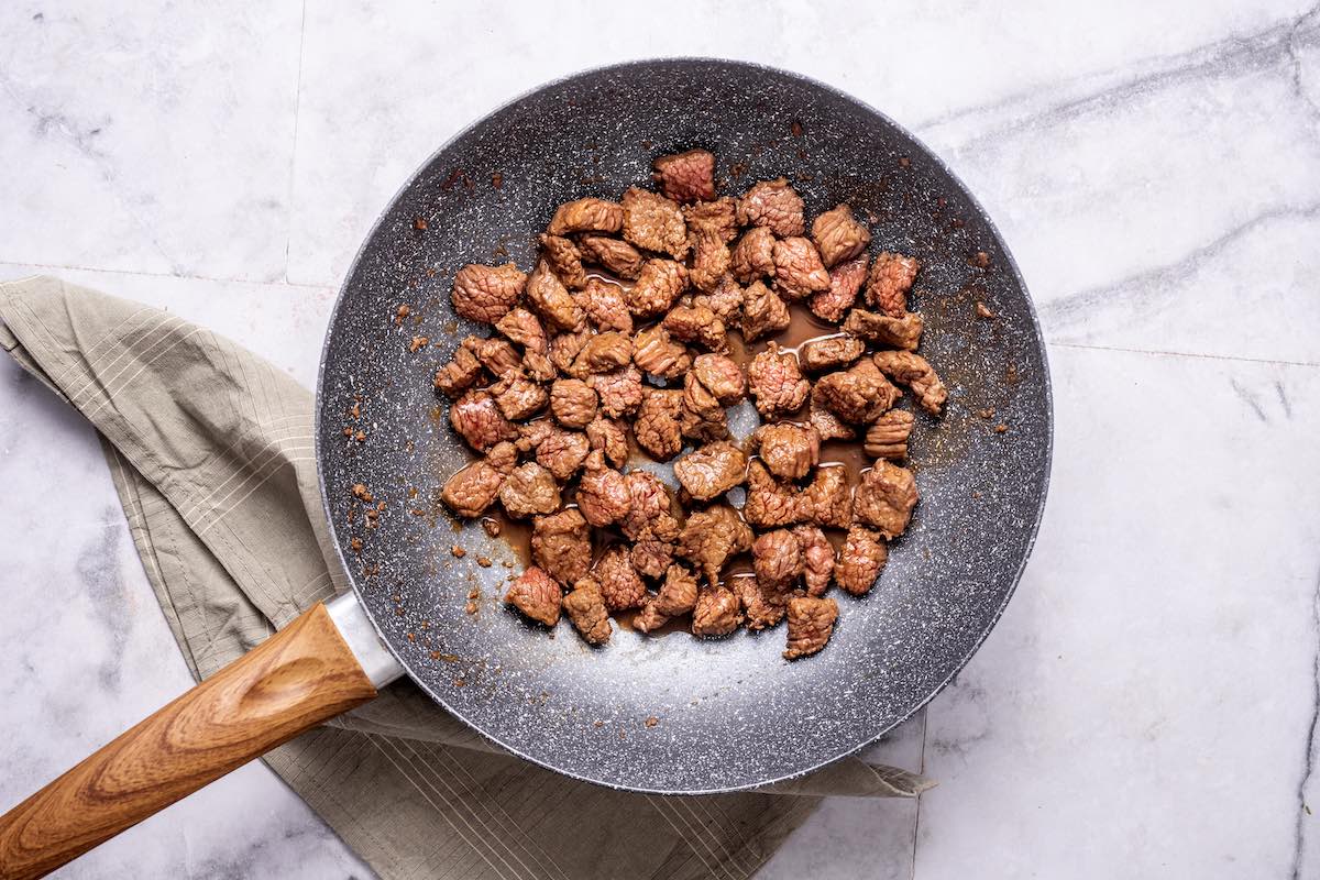 steak cooking in a skillet.