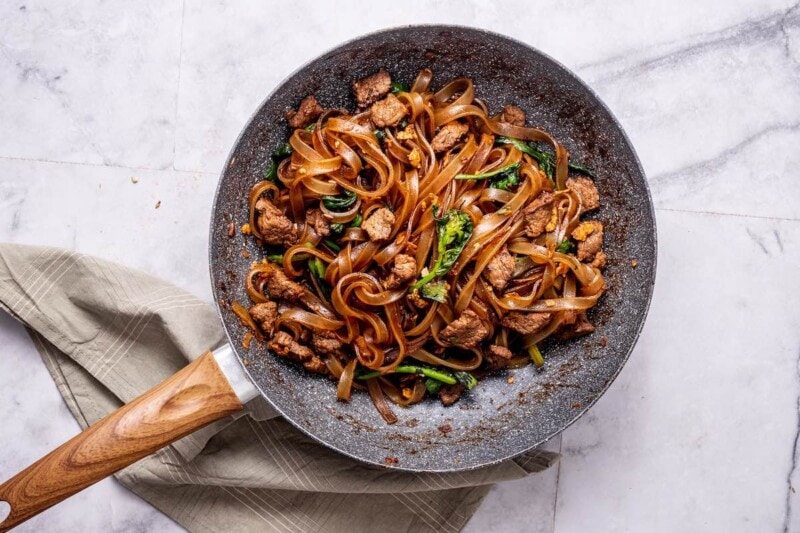 noodles, egg, broccoli, and steak bits in a skillet.