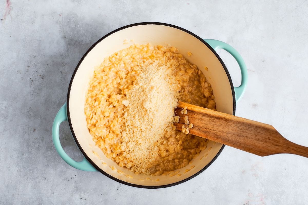 adding parmesan cheese to pasta.