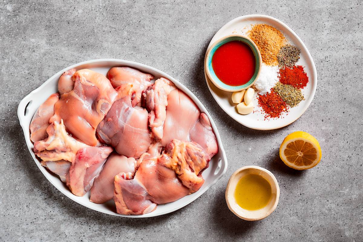 chicken pieces with marinade on a plate.