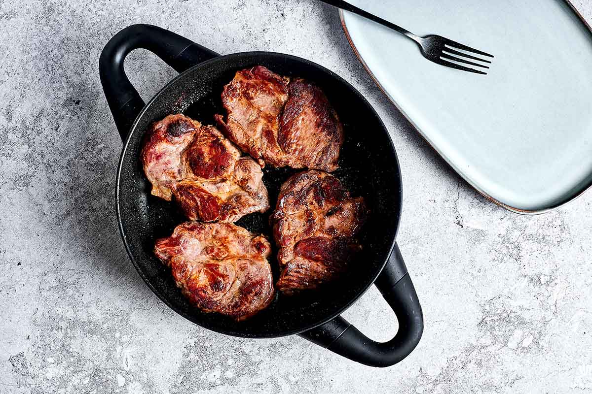 seared pork in a skillet.