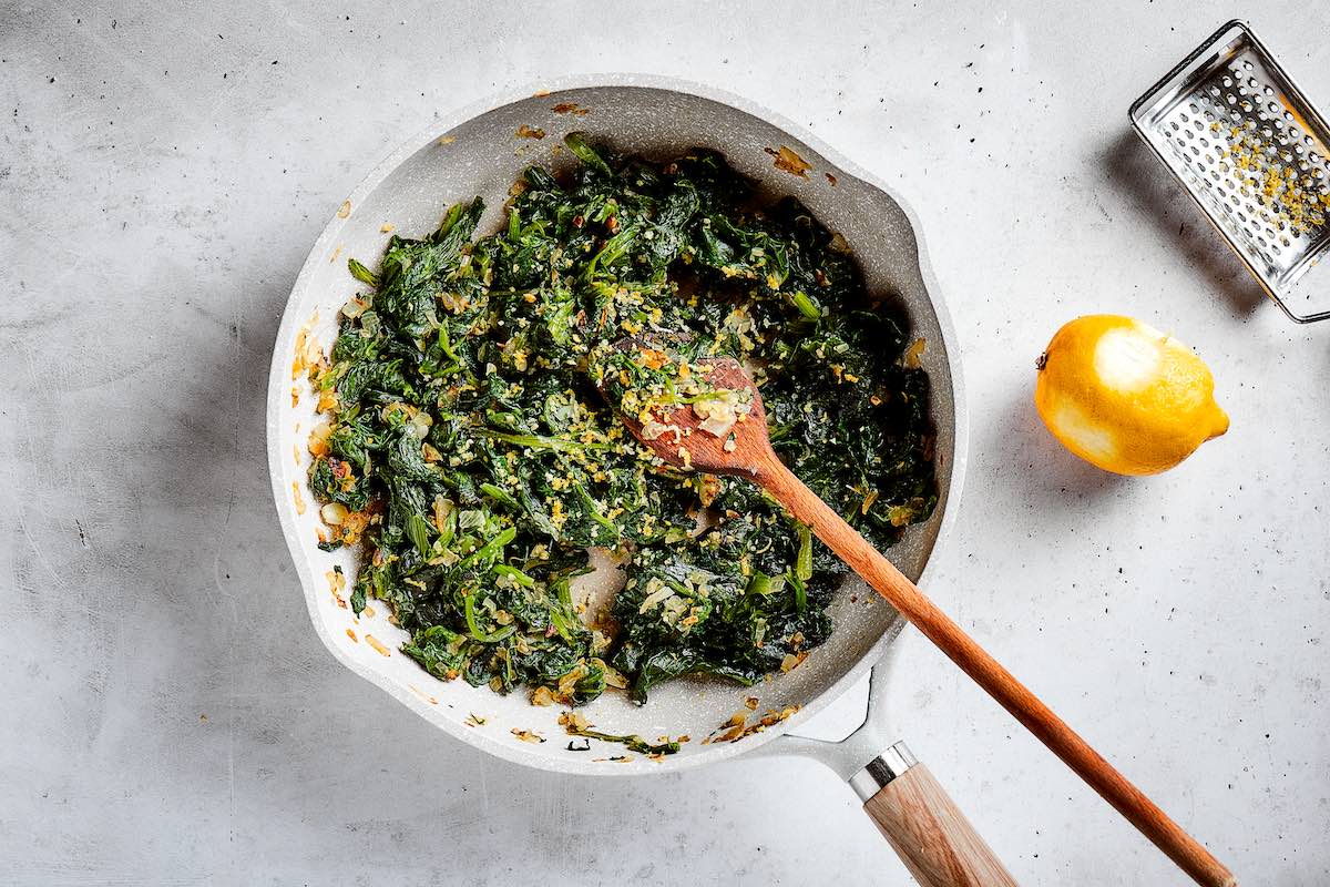 spinach with aromatics in a skillet.