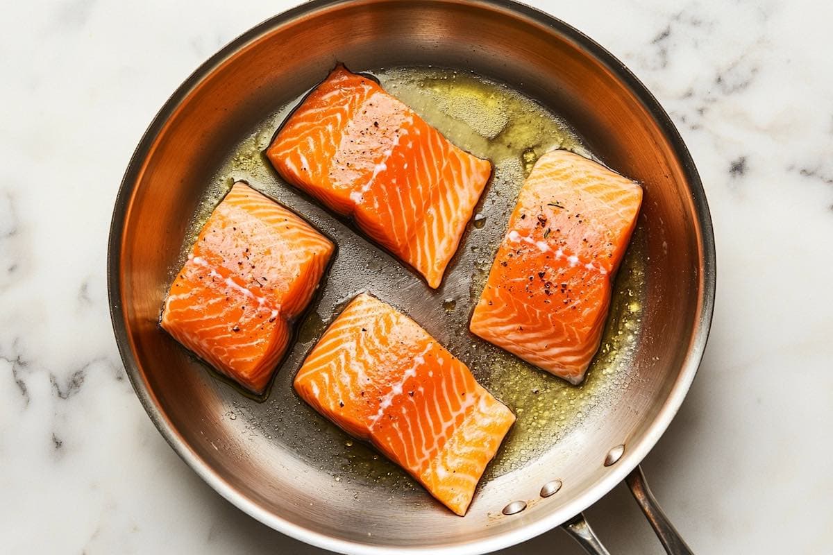 salmon fillets skin side down in a skillet.