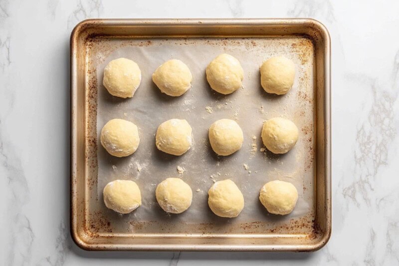 shaped balls of cookie dough on a baking sheet.