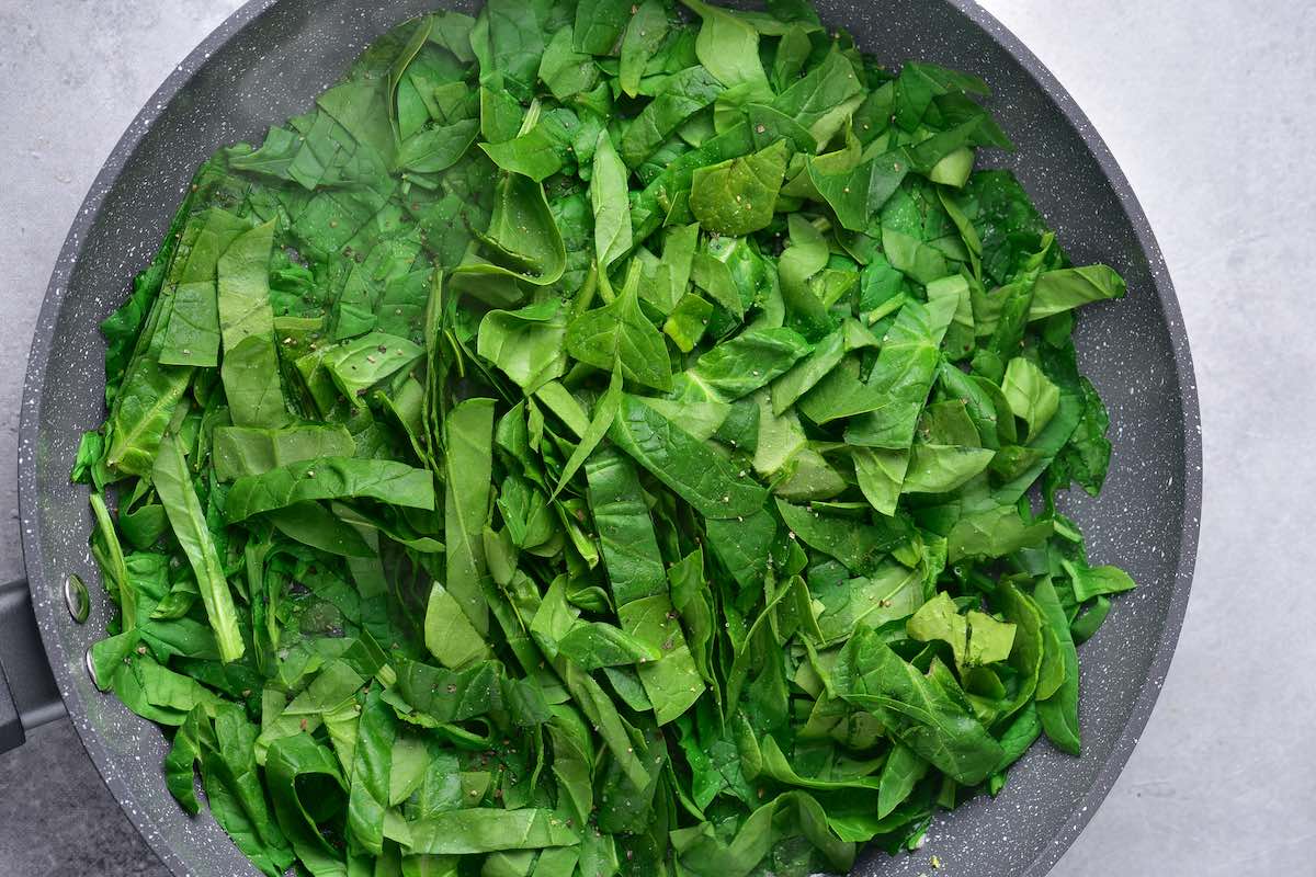 raw spinach in a skillet.