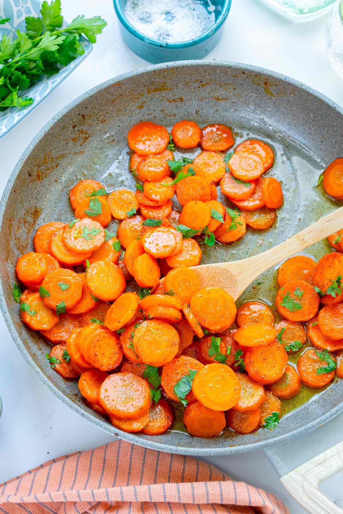 cooked carrots with fresh herbs in a skillet.