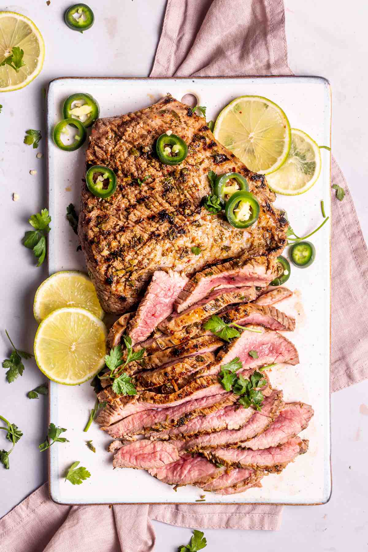 sliced carne asada with fresh lime slices.