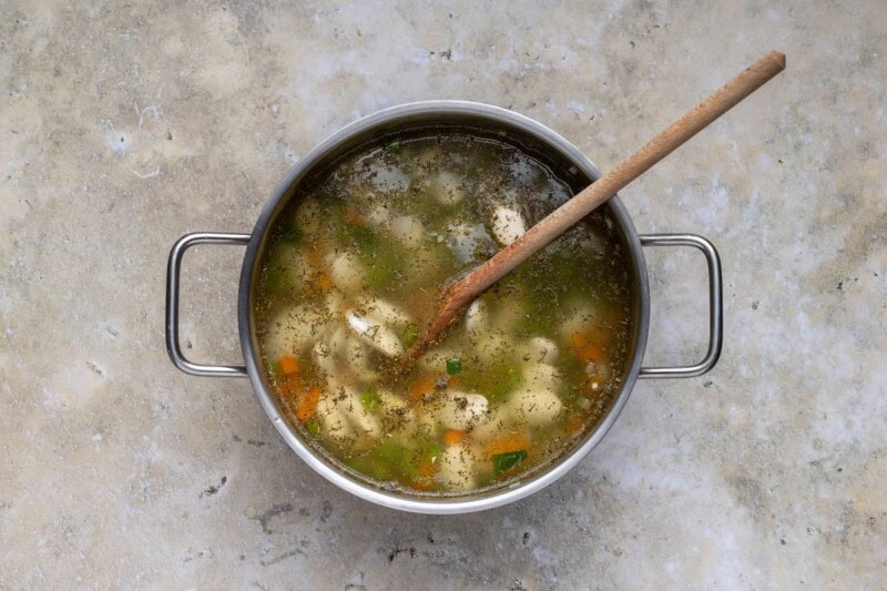 broth, butter beans, and vegetables in a pot.