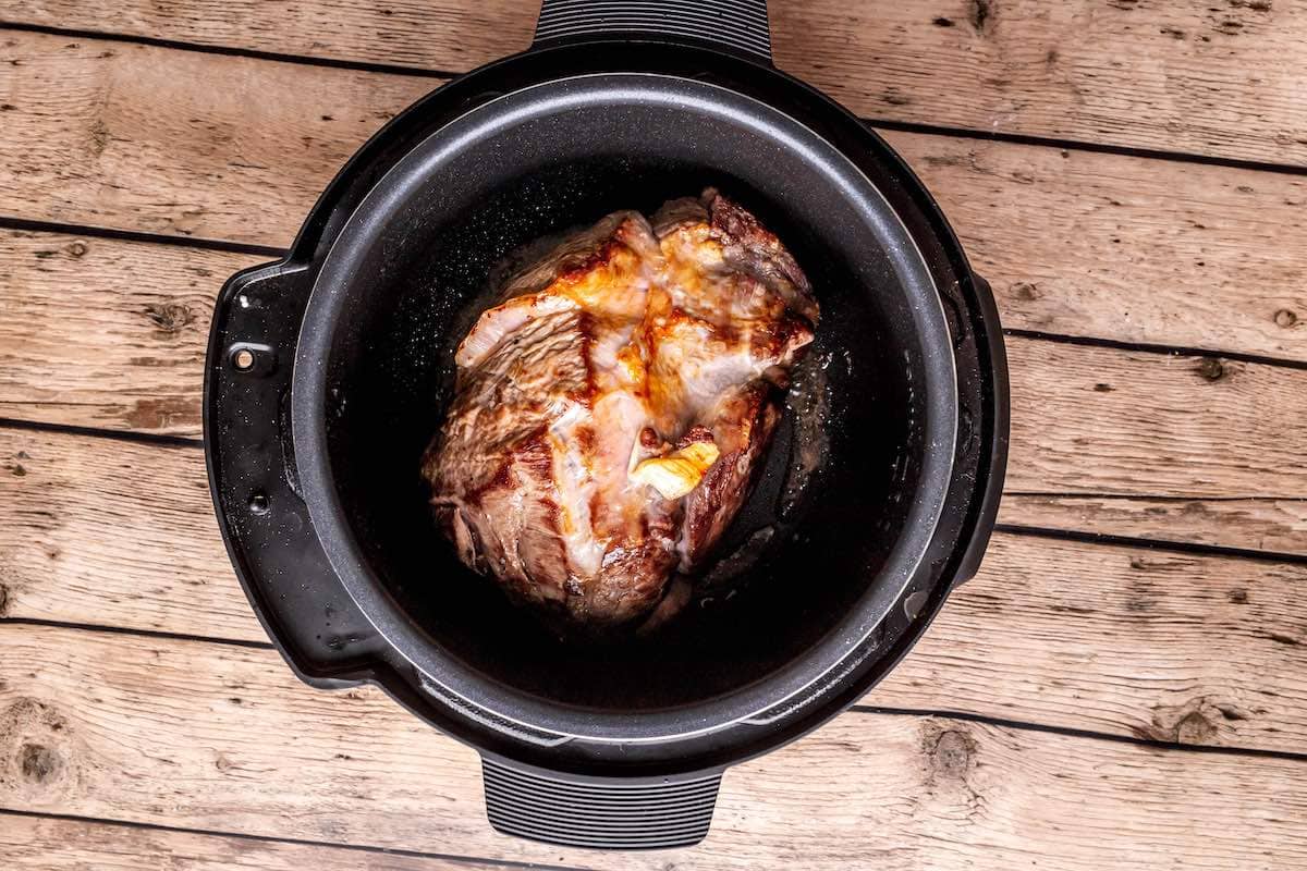 searing the chuck roast in the Instant Pot.