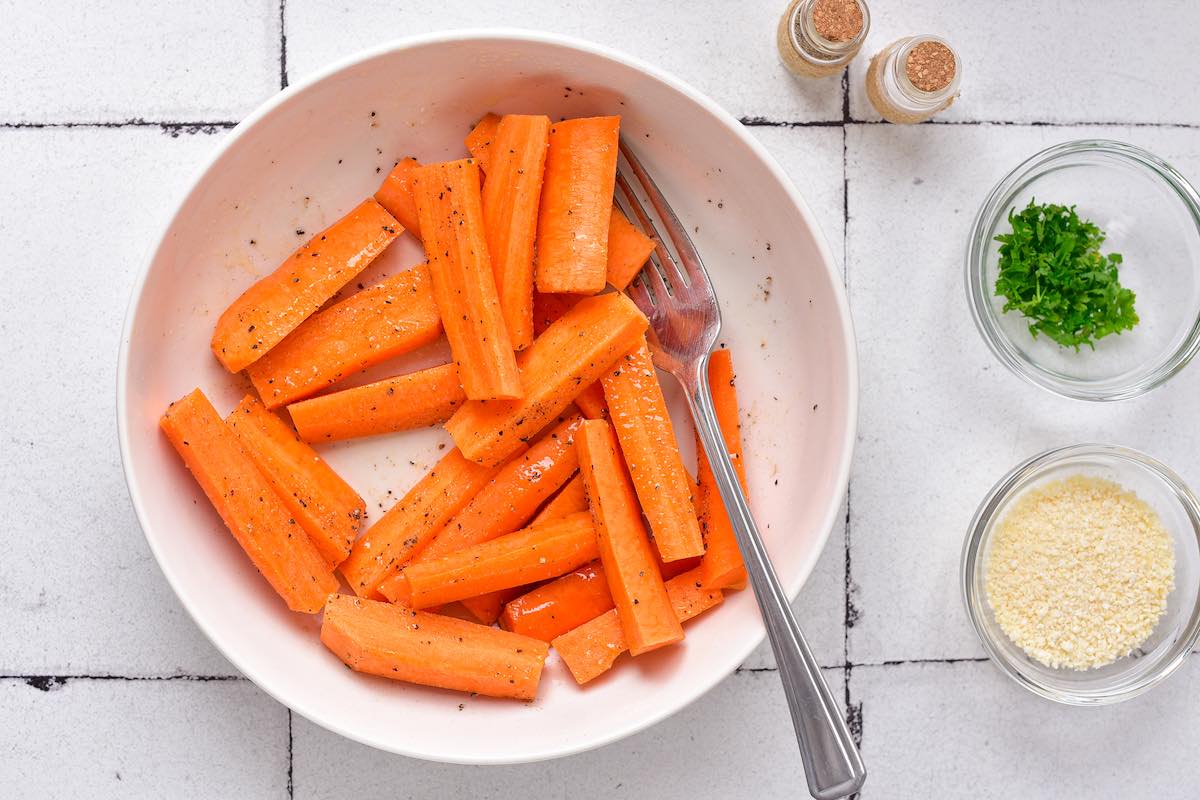 raw carrots with seasoning in a bowl.