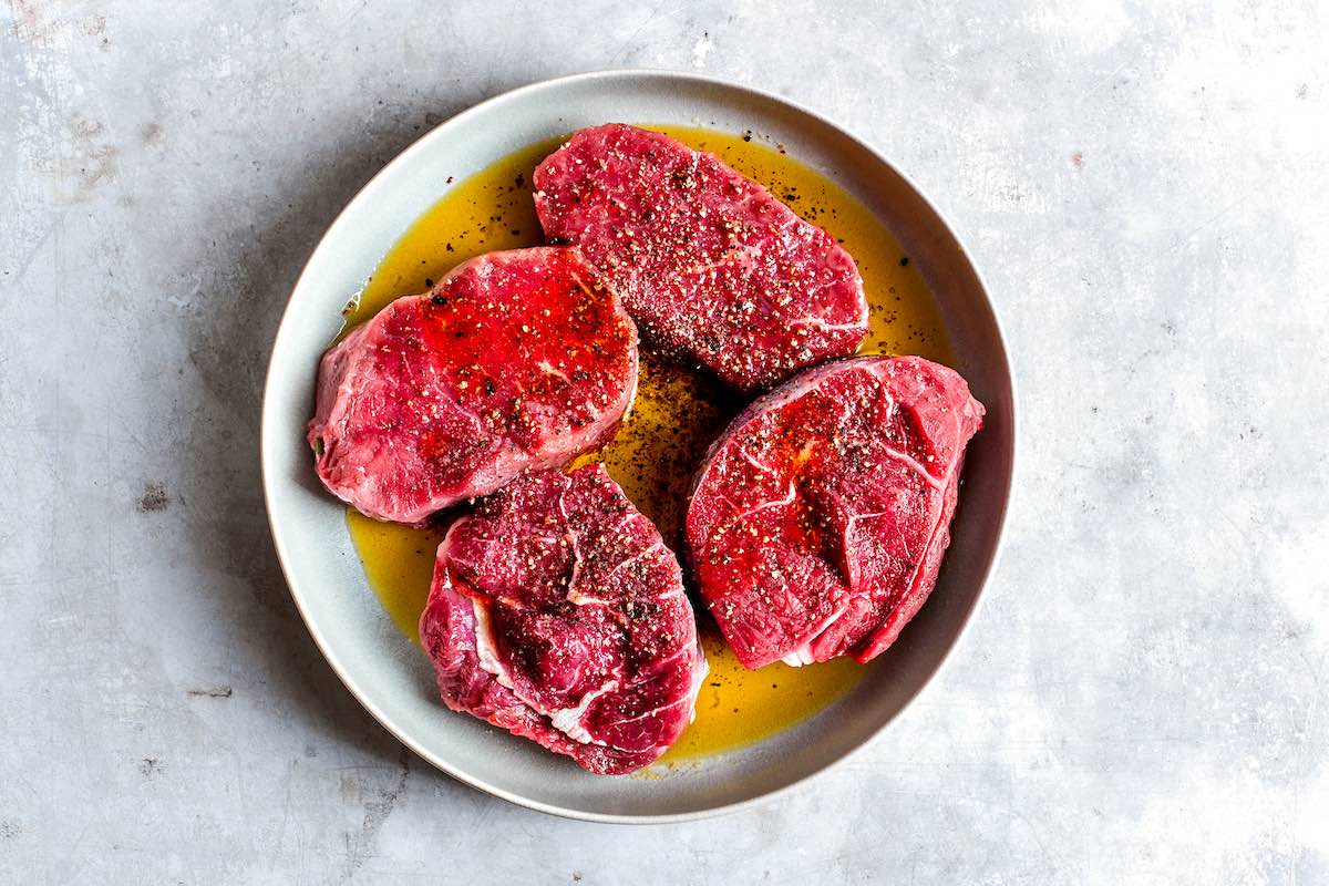 seasoned and oiled raw steaks.