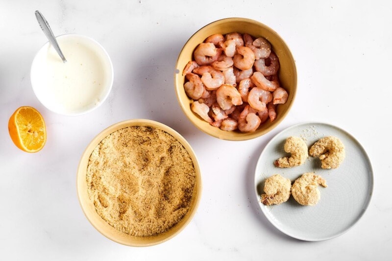 breaded raw shrimp on a plate.