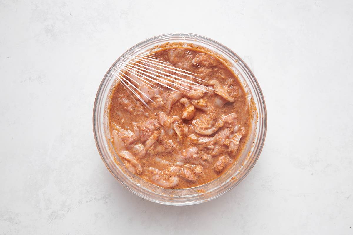 raw chicken soaking in marinade.