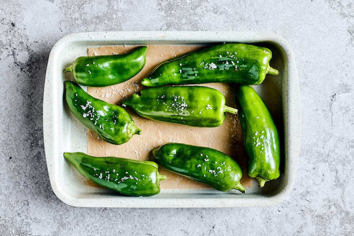 whole poblano peppers on a baking sheet.