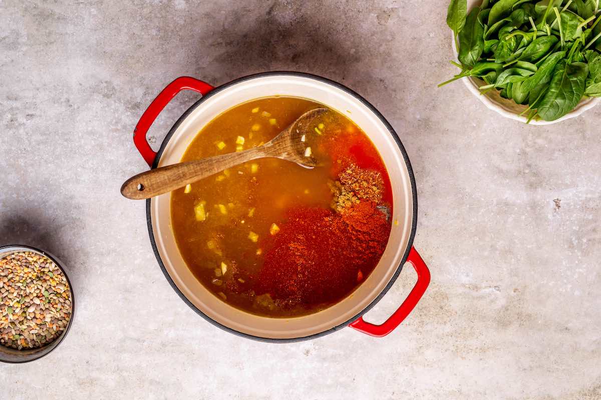 broth, spices, and vegetables in a pot.