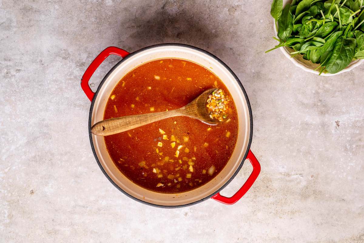 broth, vegetables, and legumes in a skillet.