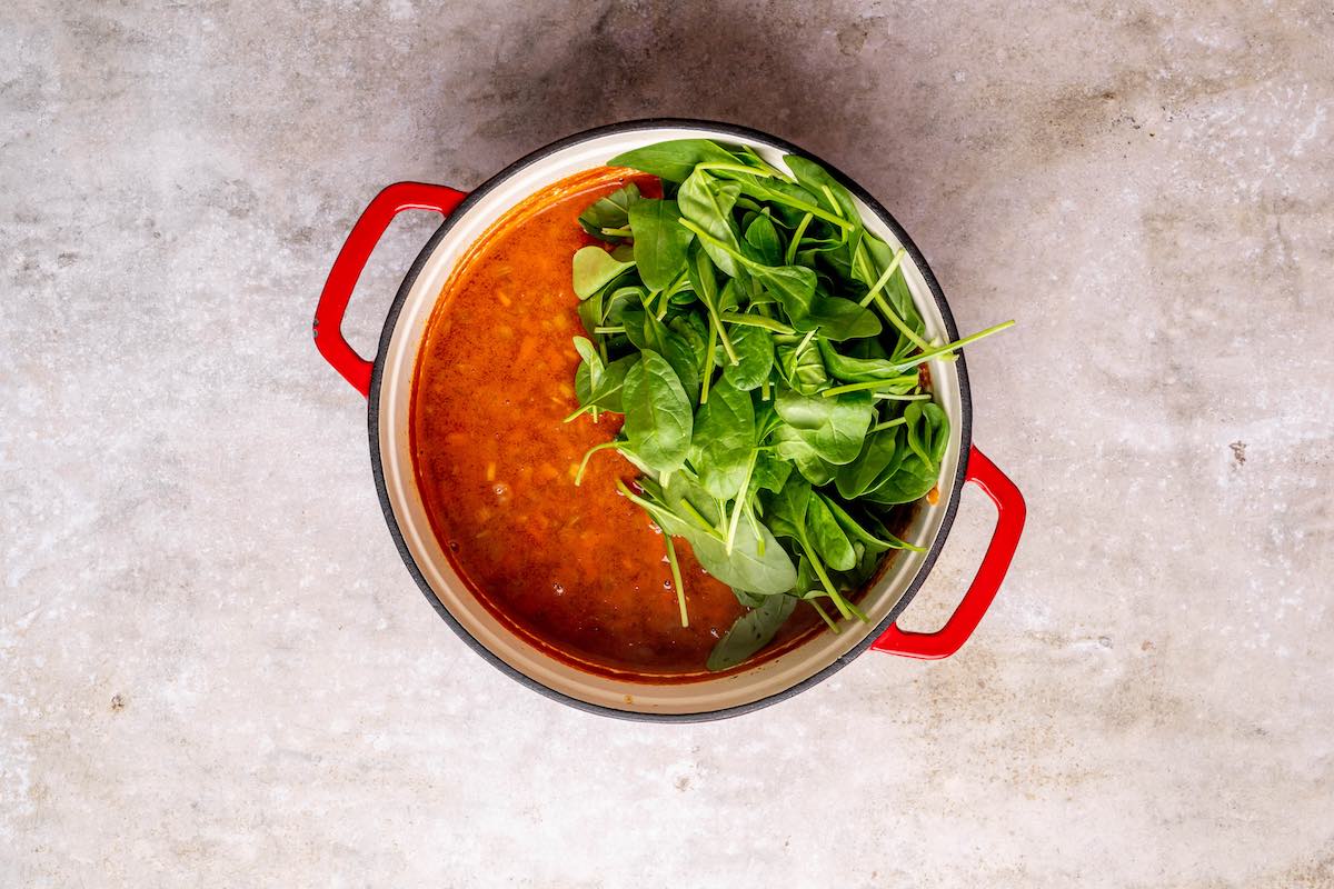 adding spinach to soup mixture.