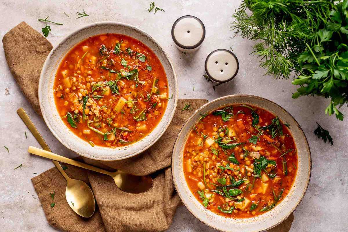 bowls of high protein soup with lentils and vegetables.