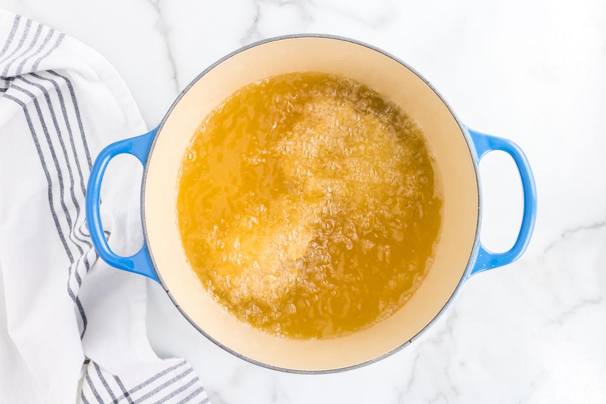 chicken deep frying in a pot of oil.