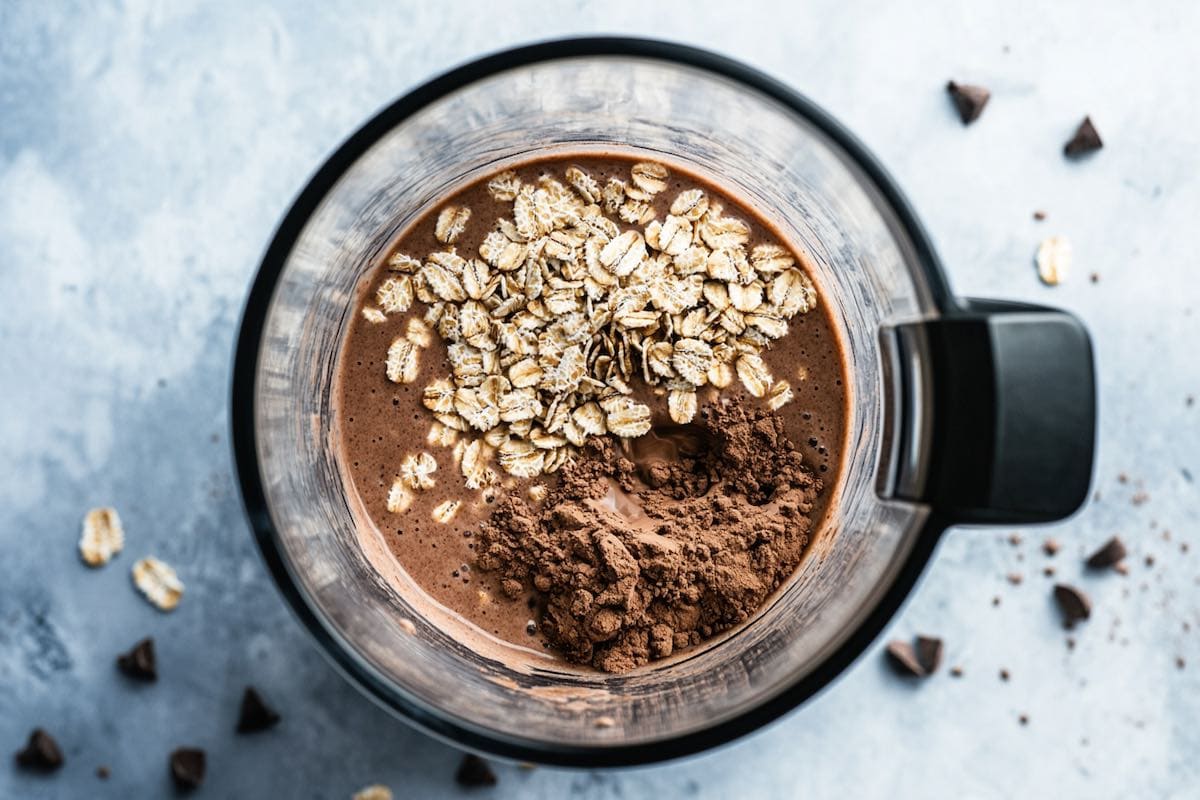 blender with milk, oats, cocoa, and peanut butter.