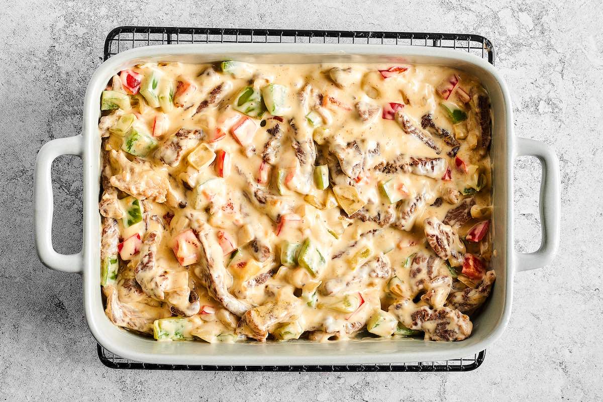 assembled cheesesteak in baking dish.