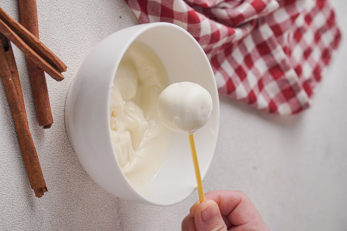 dipping cake balls in melted white chocolate.